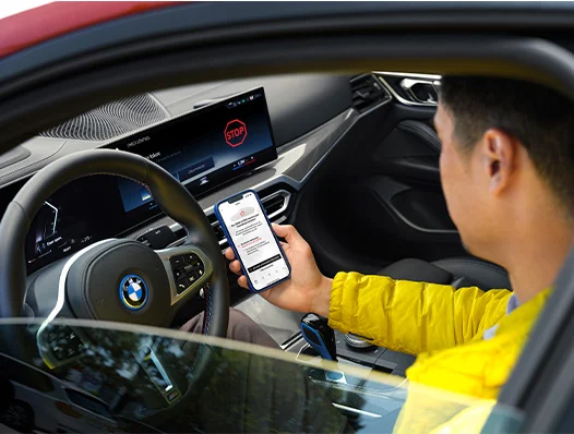Man holds smartphone with screen visible while sitting in driver